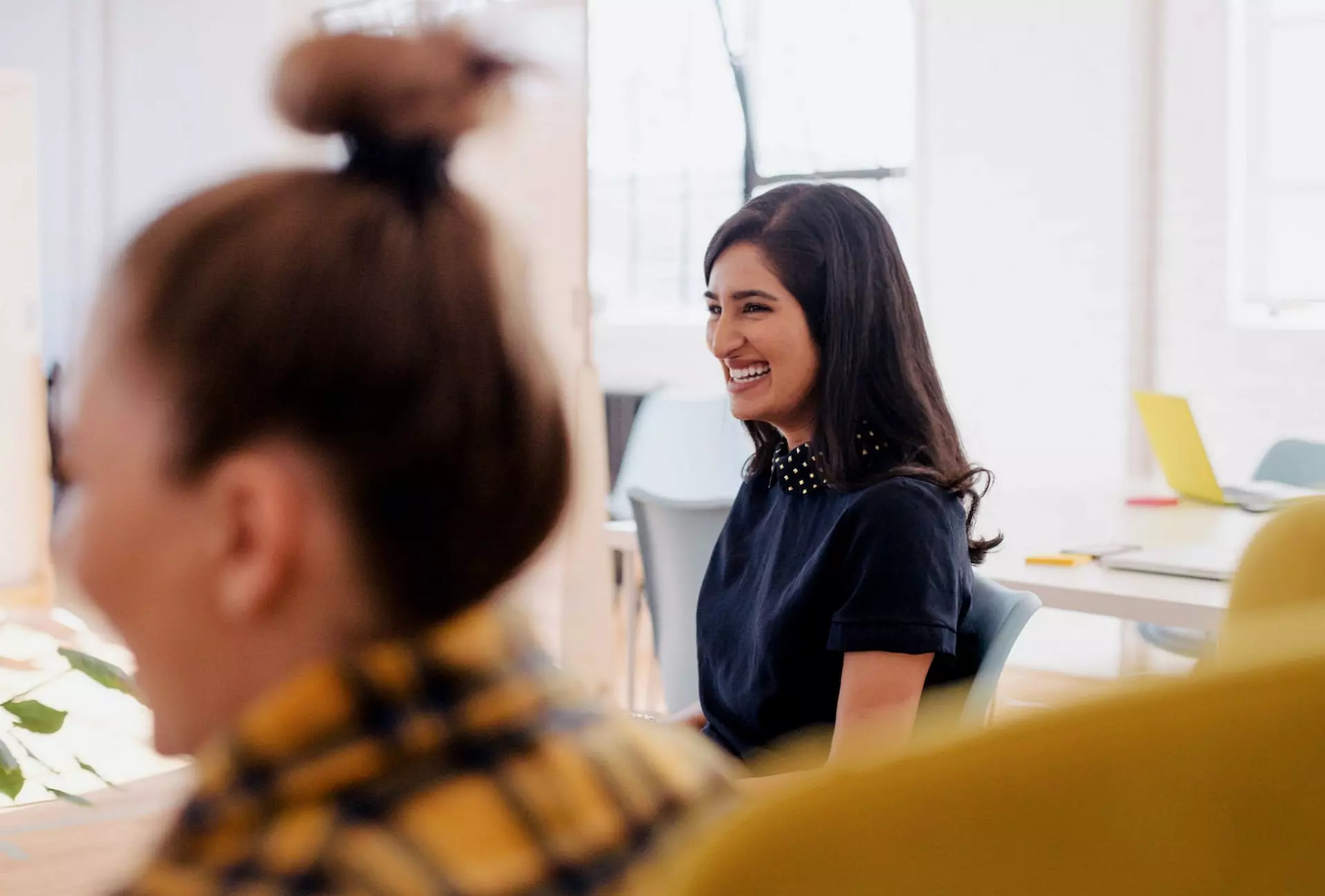 Photo d'une jeune femme souriante sur son lieu de travail
